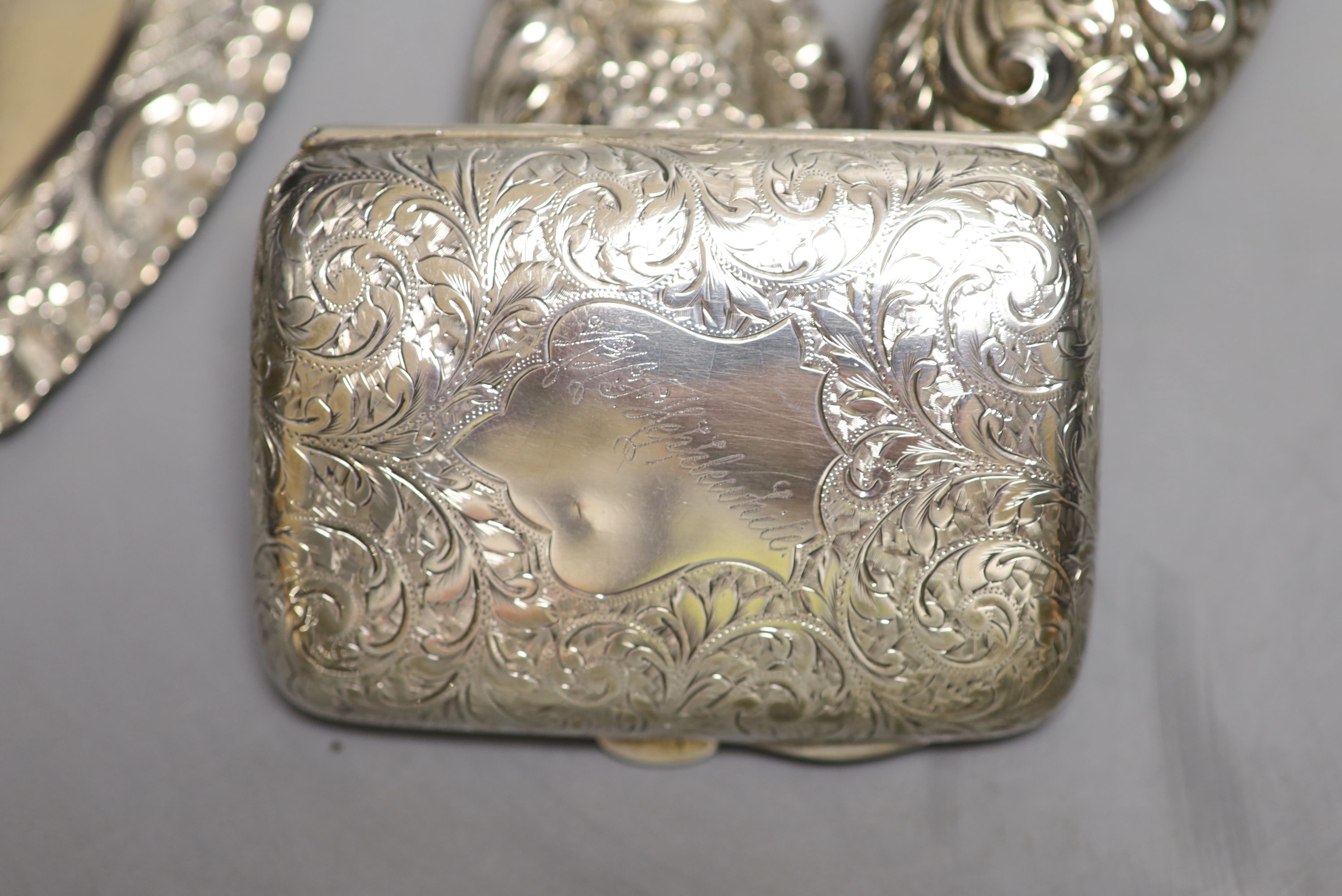 A silver cigarette case, a late Victorian silver heart shaped dish, a silver hand mirror and brush.